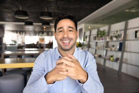 Happy young business blogger man talking on online conference chat, giving webinar, workshop, speaking at camera with toothy smile, laughing. Businessman video call head shotの写真素材