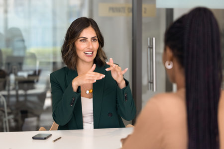 Positive successful Latin project manager woman offering idea to colleague, partner on brainstorming...