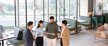 Horizontal view group of businesspeople collaborate on paperwork and digital tablet in coworking...