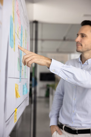 Agile work focus. Pensive mid aged businessman corporate professional select colored memo stick on...