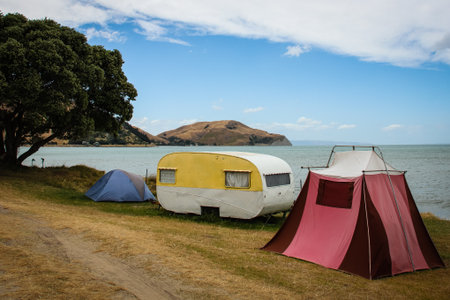 Freedom camping in retro caravan and tent by the beach at Turihaua Point, near Gisborne, New Zealandの写真素材