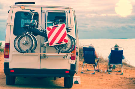 old Man and old woman, sitting next to his trailer watching a breathtaking sunrise of Cadiz, Spainの写真素材