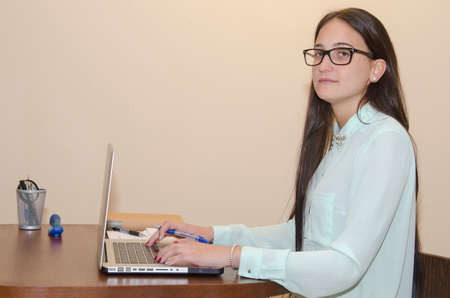 Woman with computer looking at camera with sympathetic faceの写真素材