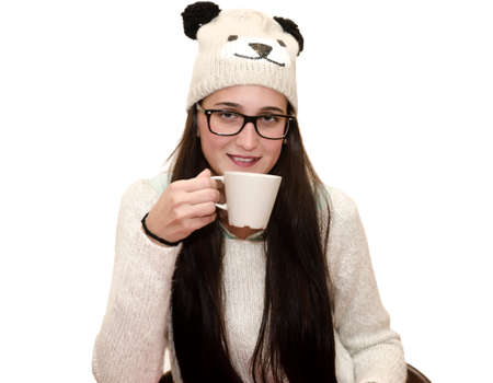 Young woman with cup in winter clothes on white backgroundの写真素材