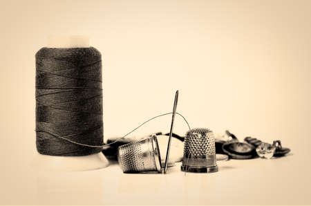 old sewing utensils, thread, needle, thimble and buttonsの写真素材