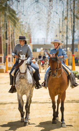 JEREZ DE LA FRONTERA, SPAIN-MAY 17: People mounted on horse and dressed in typical Andalusian costume, on fair ride on May 17, 2014 in Jerez de la frontera.のeditorial素材
