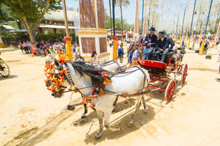 JEREZ DE LA FRONTERA, SPAIN-MAY 17: People mounted on a carriage horse, on fair ride on May 17, 2014 in Jerez de la frontera.のeditorial素材