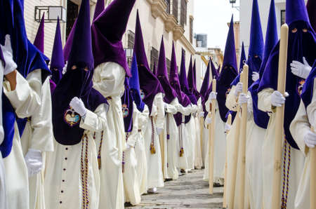SEVILLE. SPAIN - APRIL 14: Penitents of the brotherhood of "El Beso de Judas"  In their procession by Seville, In Holy week on april 14, 2014 in sevilleのeditorial素材
