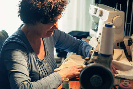 Middle aged woman sewingの写真素材