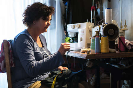Middle aged woman sewingの写真素材