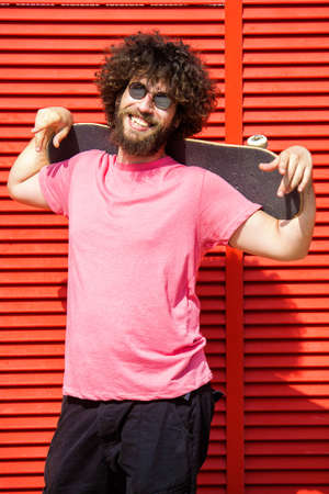 Man with skateboard on red backgroundの写真素材