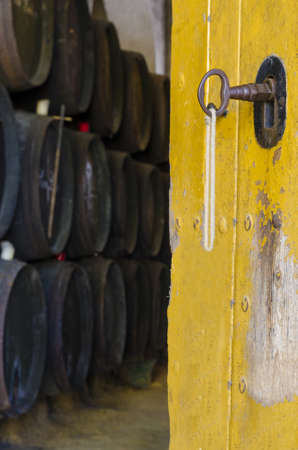 Door witn keys of old cellar with barrels backgroundの写真素材