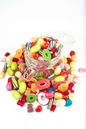 Glass jar full of candies isolated in white background.の写真素材