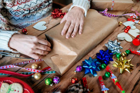 Close-up of hands wrapping Christmas gifts.の写真素材