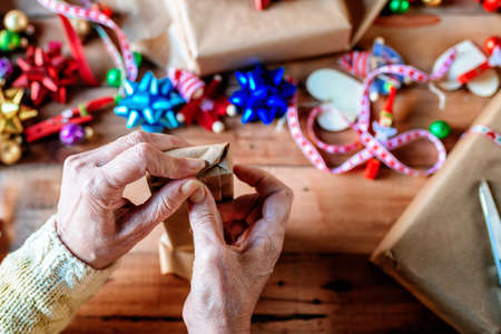 Close-up of hands wrapping Christmas gifts.の写真素材