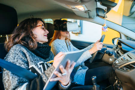 Driving instructor teaching  a student using virtual reality glasses.の写真素材