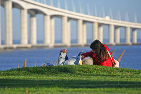couple in the grass near the riverの写真素材