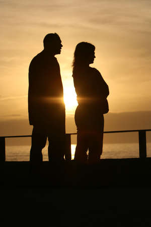 sunset couple - looking the sea with sun in the middleの写真素材
