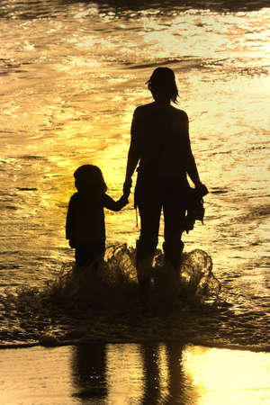 mother and son at sunset in the beach
