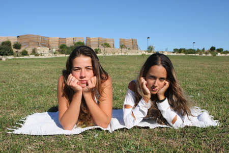 two beautiful young women relaxing in the grassの写真素材