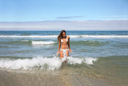 beautiful girl in bikini being splashed by cold wave 