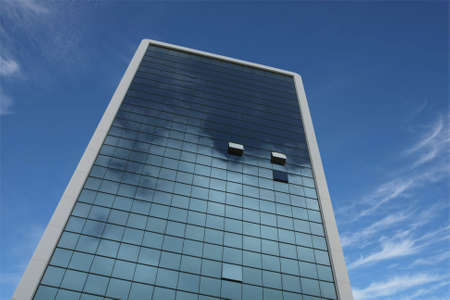 highrise glass building with sky and clouds