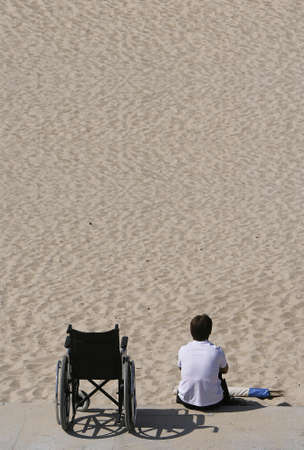 woman and wheel chair in the beachの写真素材