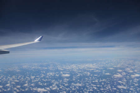 View of jet plane wing with cloud patternsの写真素材