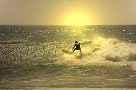 sunset surfer in the waveの写真素材