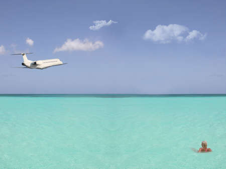 blonde woman in the sea with an airplaneの写真素材