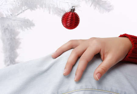 woman hand with a white christmas tree in the backgroundの写真素材