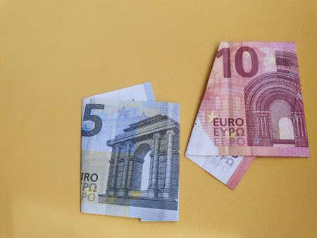 european banknotes of different denominations and yellow background for advertising