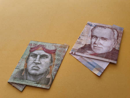 peruvian banknotes of different denominations and yellow background for advertisingの写真素材
