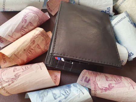 black leather wallet and brazilian banknotes of different denominationsの写真素材