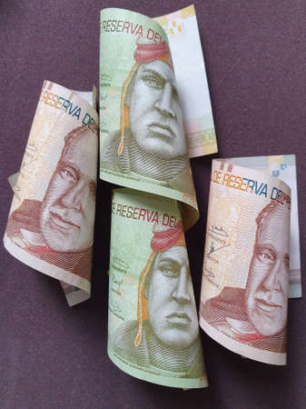 peruvian banknotes of different denominations and brown background