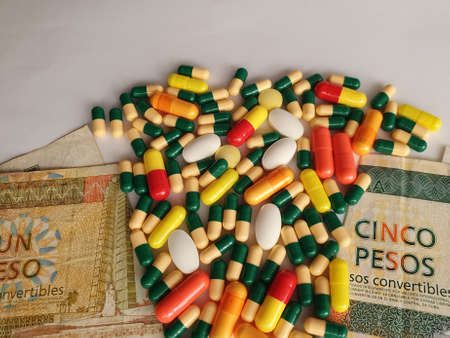 Cuban banknotes of different denominations, capsules and medicine pillsの写真素材