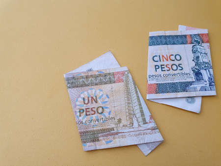 Cuban banknotes of different denominations and yellow background for advertisingの写真素材