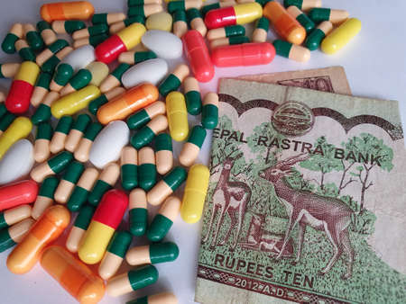 Nepalese banknote of ten rupees, capsules and medicine pills