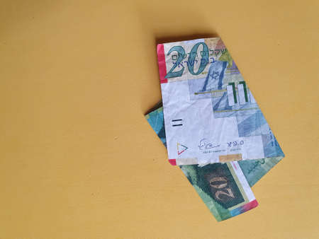 Israeli banknote of twenty shekels and yellow background for advertisingの写真素材