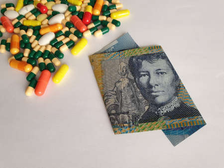 Australian banknote of ten dollars, capsules and medicine pills
