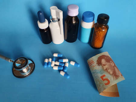 New Zealand banknote of five dollar, stethoscope, medicine bottles and pills on the blue backgroundの写真素材