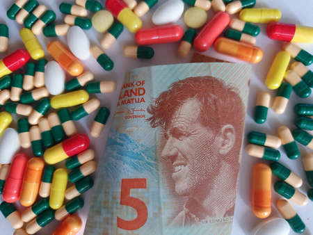 New Zealand banknote of five dollars, capsules and medicine pillsの写真素材