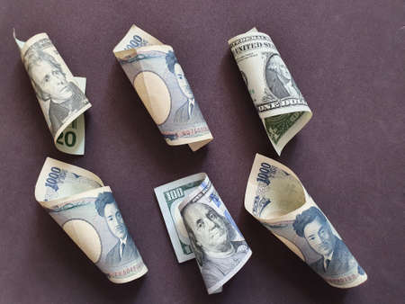 American banknotes and Japanese bills on the brown background