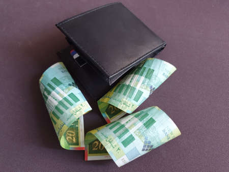 black leather wallet and Israeli banknotes of twenty shekels