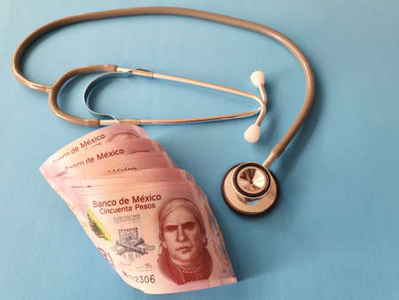 mexican banknotes of fifty pesos and stethoscope on the blue backgroundの写真素材