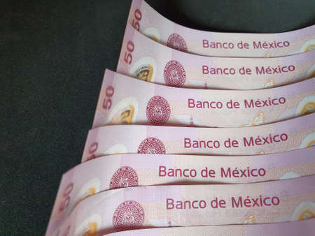 stacked mexican banknotes of fifty pesos on the black backgroundの写真素材