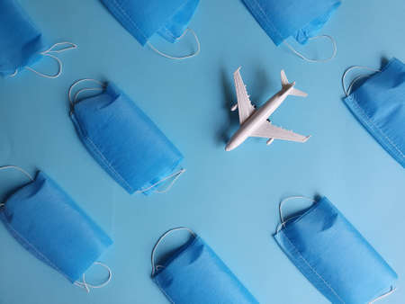 figure of a white plastic airplane and masks on the blue background