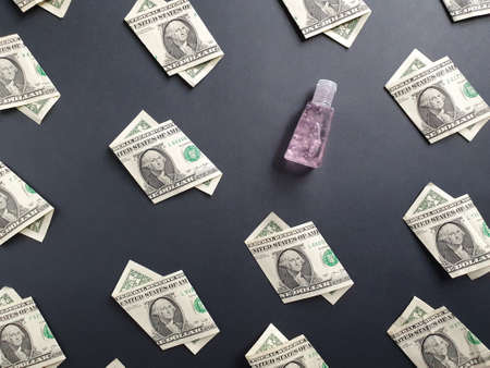american one dollar bills and bottle of gel alcohol on the black backgroundの写真素材