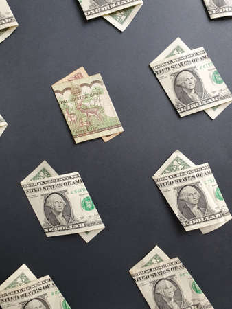 american one dollar bills and nepalese banknote of ten rupees on the black background