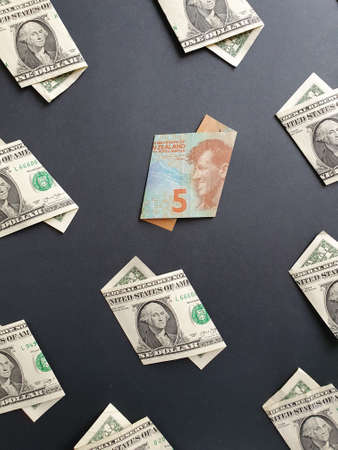 american one dollar bills and New Zealand banknote of five dollars on the black backgroundの写真素材